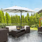 Beige patio umbrella open over outdoor seating, central dark pole and weighted base