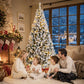 Snow-flocked prelit Christmas tree with full conical shape and warm lights, standing upright.