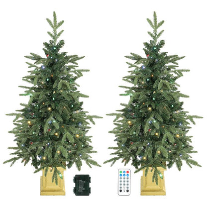 Set of 2 prelit artificial Christmas trees with dual-color lights and golden bases.
