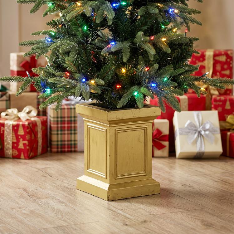 Prelit Christmas tree in gold planter with multicolor lights, close-up