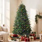 Prelit Colorado blue spruce Christmas tree with multicolored lights and wrapped gifts at base