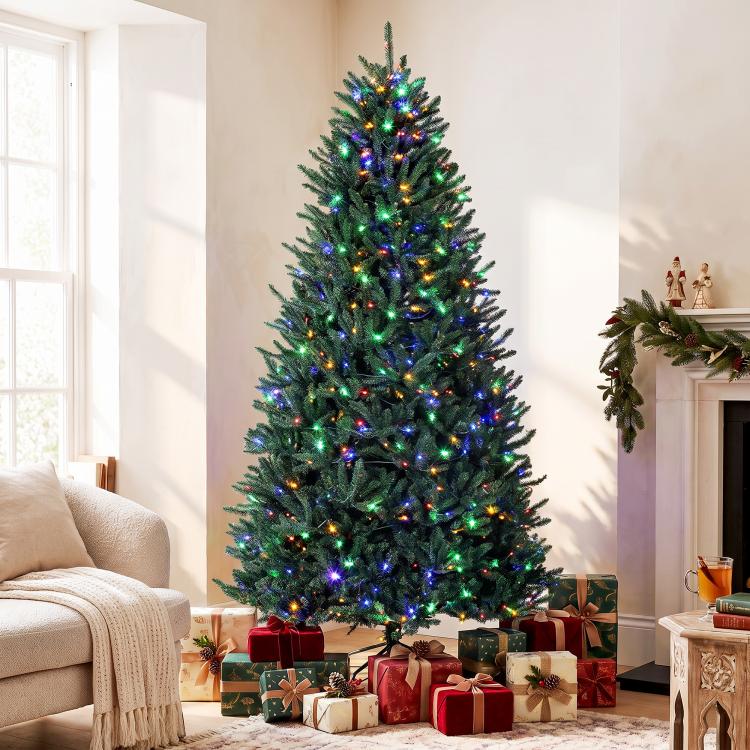 Tall artificial Christmas tree with green needles and multicolored light strands
