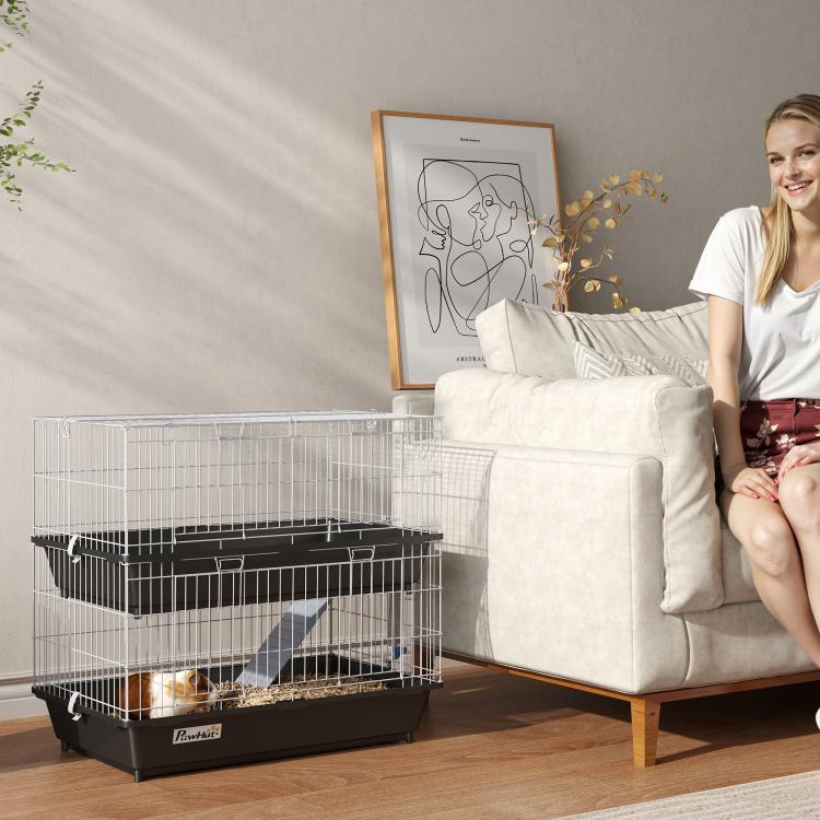 Two-tier wire small animal cage with black trays and ramp, set on a stand