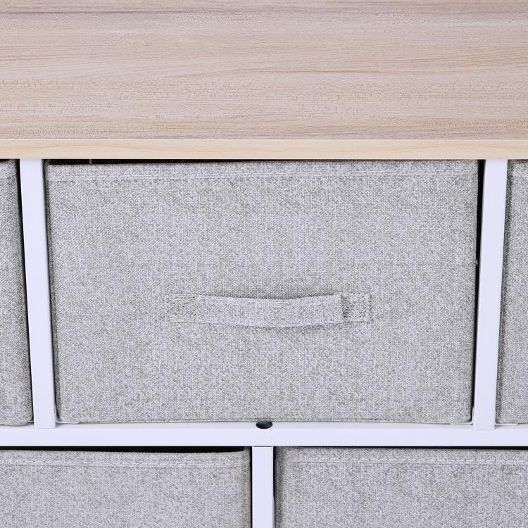 Close-up of light gray fabric drawer with handle under wood top, white frame.