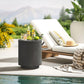 Charcoal gray outdoor cooler bar table with lid and bottles on top