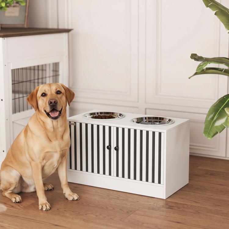 Dog sitting beside a white elevated feeding station with two stainless steel bowls