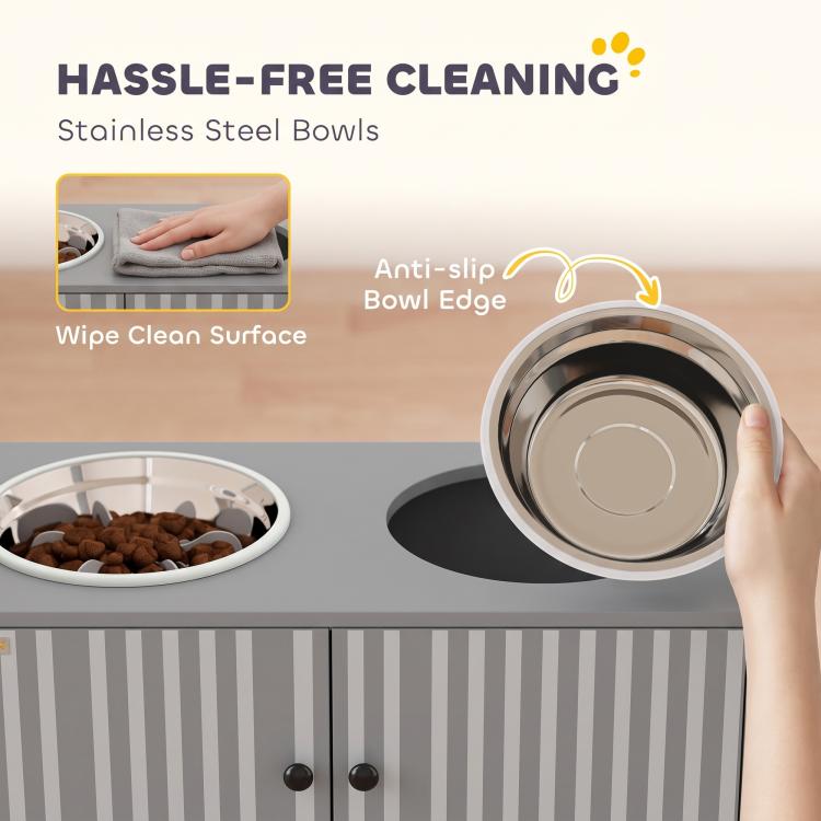 Stainless steel dog bowl close-up on gray feeding cabinet with hand lifting bowl