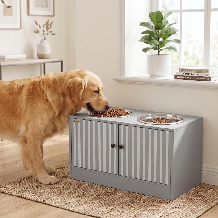 Golden dog eating from raised bowls on a gray dog feeding station cabinet