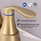 Brushed gold bathroom faucet with single spout and two handles, close-up view