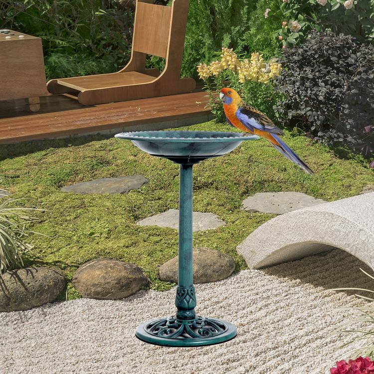 Outdoor bird bath pedestal with teal bowl and colorful bird near the rim