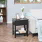 Black side table with drawer and open shelf, square top and dark wooden frame.