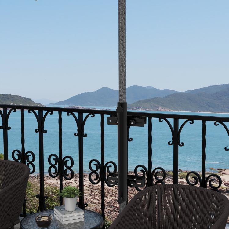 Black umbrella holder stand mounted to railing post with clamp plates