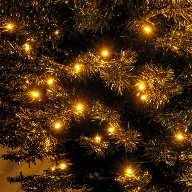 Artificial pencil Christmas tree with warm white LEDs; close-up of dark branches