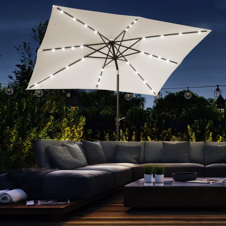 Cream white solar LED patio umbrella with illuminated edge lights and open canopy.