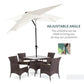 Cream white patio umbrella with adjustable tilt angle and open canopy above table.