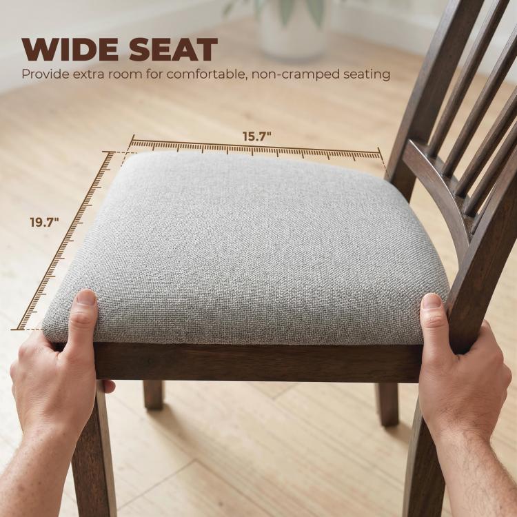 Gray upholstered dining chair seat with hands measuring the seat width