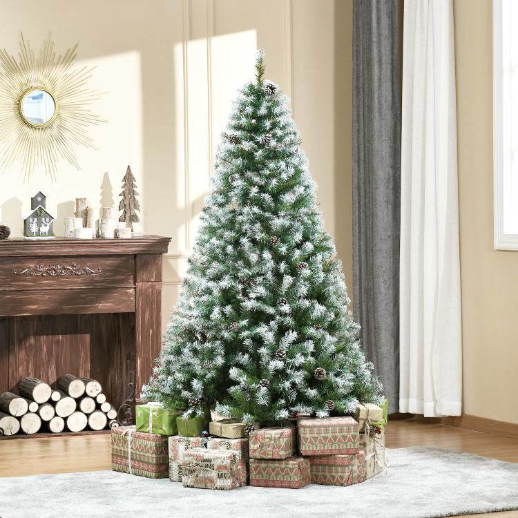 Snow-dusted artificial fir Christmas tree with pine cones on a metal stand