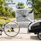 White pet bike trailer with connector hitch attached near bicycle front wheel