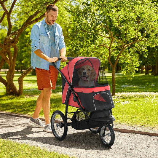 Red and black 3-wheel pet stroller holding a dog inside under the mesh canopy