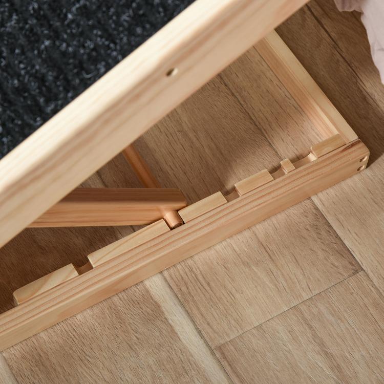 Foldable pet ramp with black non-slip tread and wooden frame, close-up