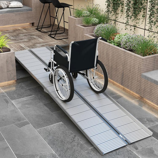 Aluminum wheelchair ramp with textured traction surface supporting a wheelchair over a step