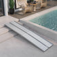 Aluminum threshold ramp with textured silver surface and raised sides for curb transition