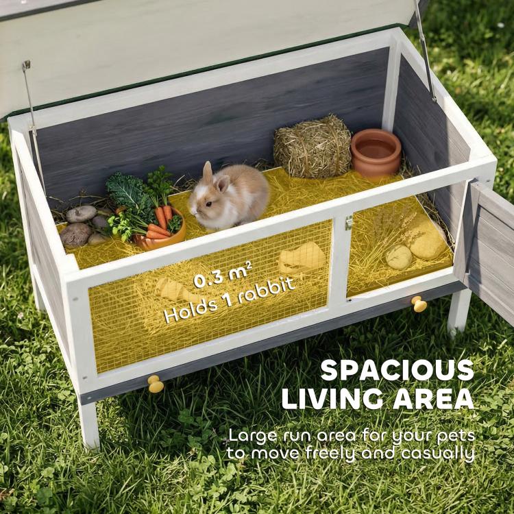 Open outdoor elevated rabbit hutch interior with bedding, bowl, and removable base area