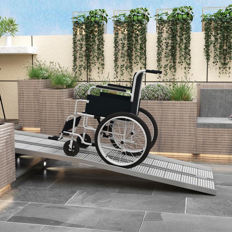 Wheelchair on aluminum ramp at doorway with ribbed non-slip panels and side rails
