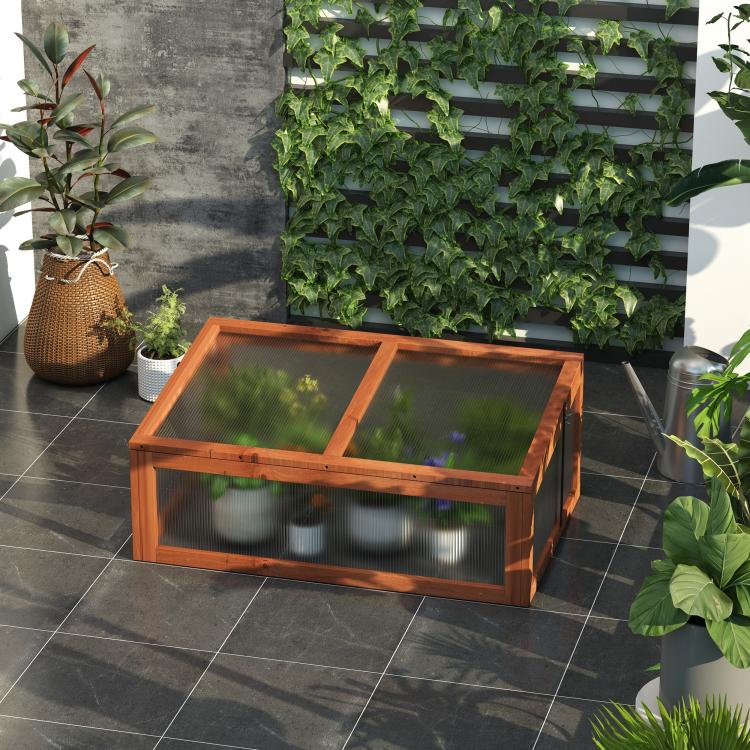 Mini wooden cold frame greenhouse with open lid, clear panels, and plants on deck