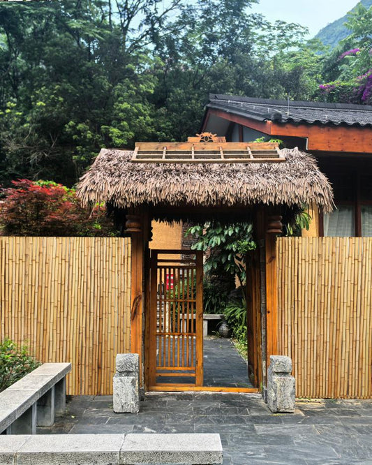 Installed bamboo privacy fence screen with vertical slats behind an outdoor walkway.