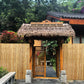 Natural bamboo fence panel with thatched roof gate and vertical bamboo poles