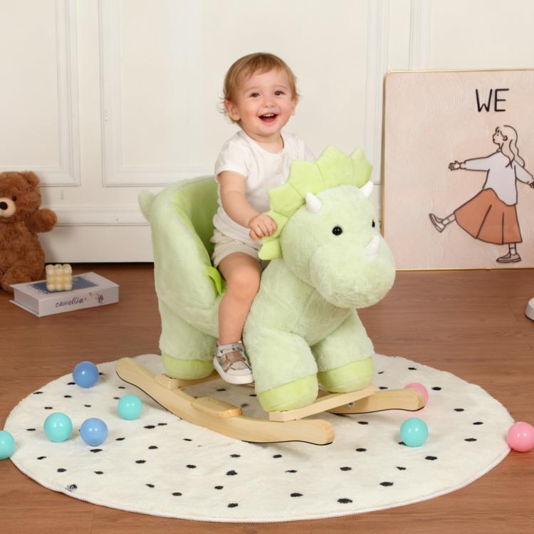 Green plush dinosaur rocking horse ride-on with wooden base and safety belt; toddler seated