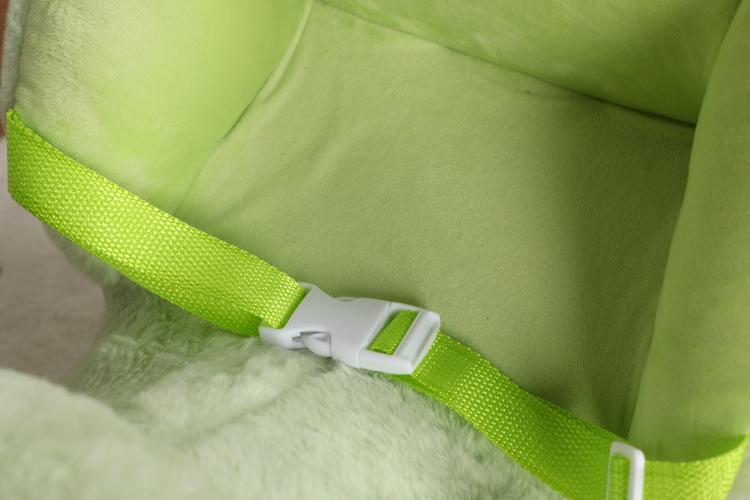 Green plush rocking horse with front safety belt and white buckle