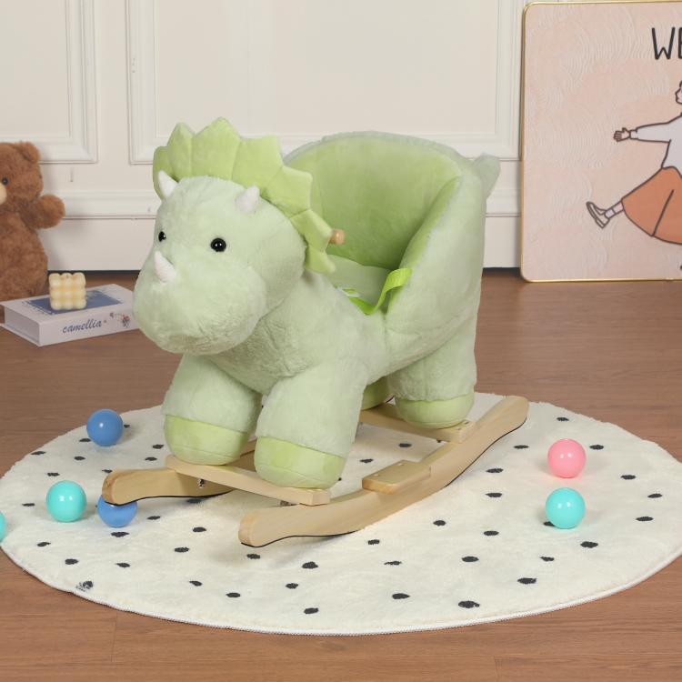 Green plush dinosaur rocking horse with wooden rockers, three-quarter view on play mat