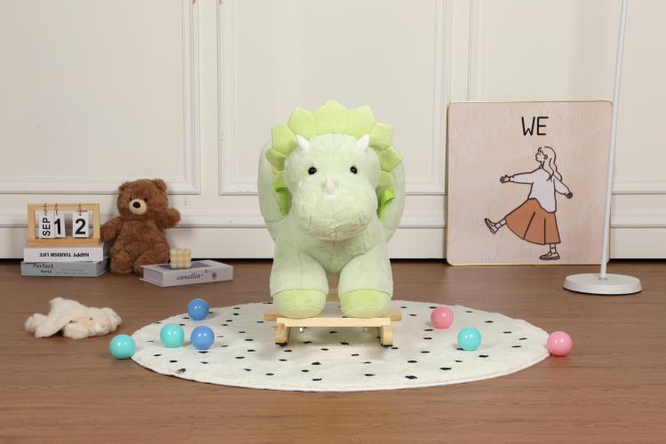 Green plush dinosaur rocking horse ride-on with wooden base, centered on patterned play mat
