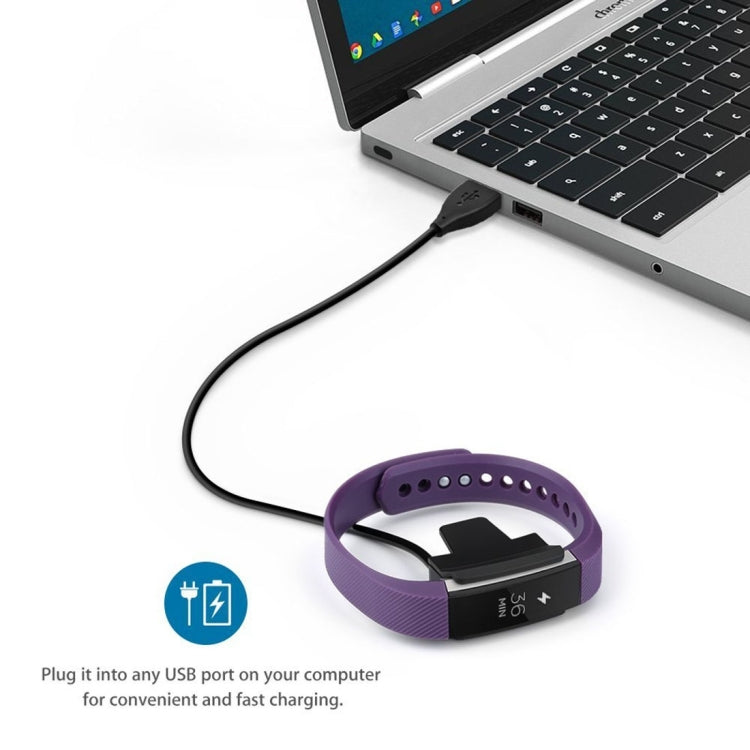 Purple Fitbit Alta watch band with charging clip on black USB cable