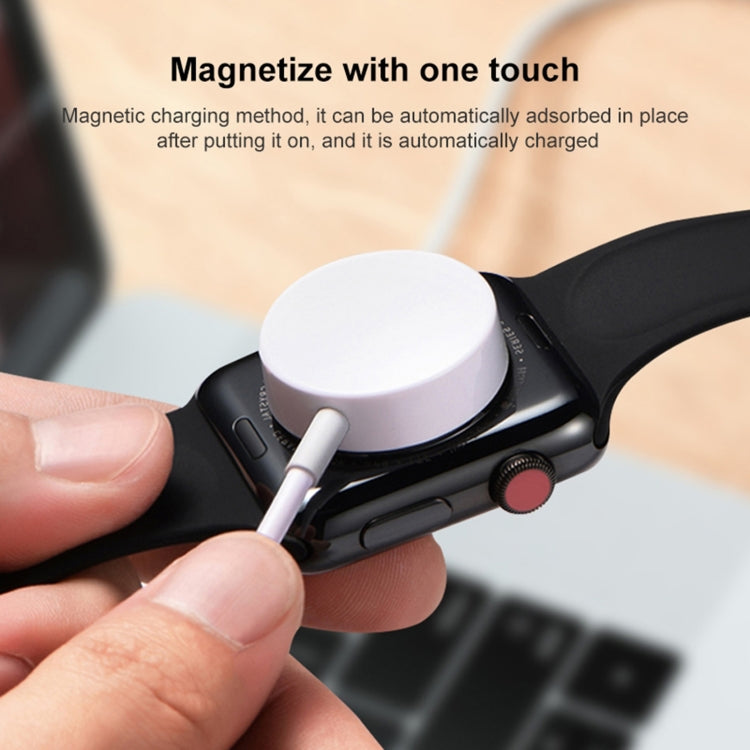 White magnetic charging puck connected to Apple Watch charging port