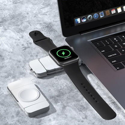 Magnetic smartwatch charging dock with black strap, green power indicator, and contact plate