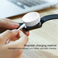 White magnetic charging puck for a watch with cable, held by fingers