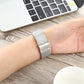 Silver mesh stainless steel watch band on wrist for Apple Watch 38mm, fold-over clasp