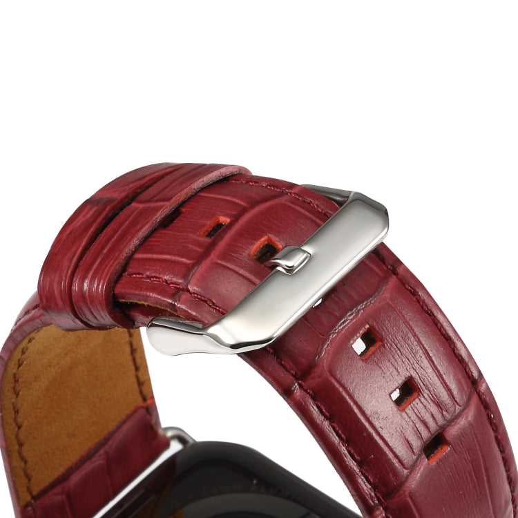 Close-up of dark red crocodile-grain leather watch band with metal buckle