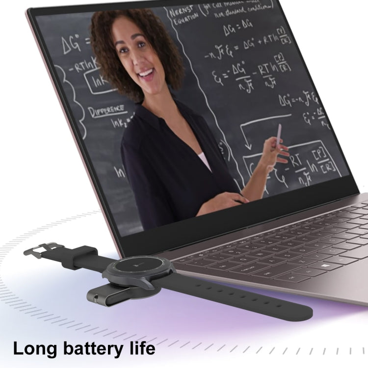 Portable magnetic wireless watch charger positioned on laptop desk, black