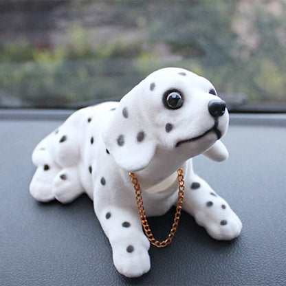 Dalmatian plush dog car ornament with brown chain, lying on car dashboard