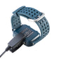 Garmin watch with blue perforated band and charging clip connected to cable