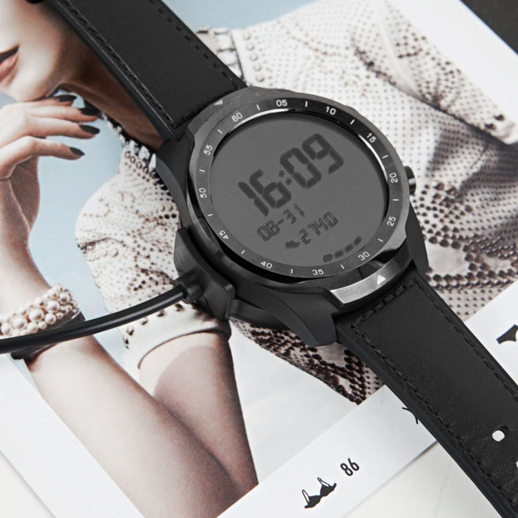 Black smartwatch with digital display and charging cable attached