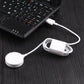 White charging puck connected by cable to USB port near a laptop keyboard