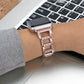Rose gold diamond watch band on wrist with smartwatch case and metal clasp