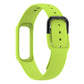 Green silicone watch band with metal spring bars and rectangular connector, angled view.