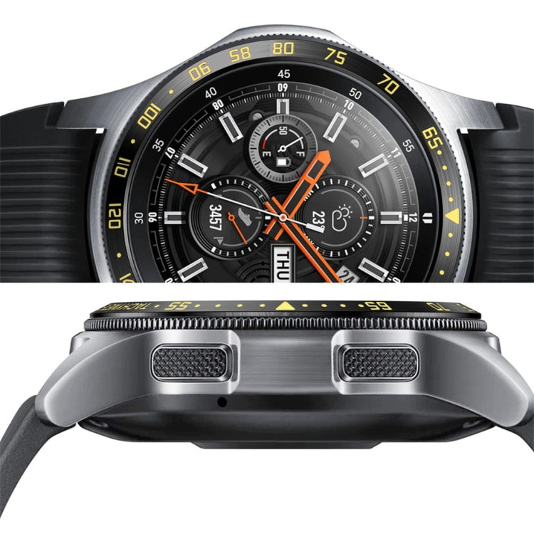 Close-up of black watch protective bezel with silver guards and orange dial accents
