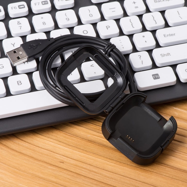 Coiled black smartwatch USB charger cable with charging dock cradle